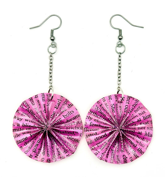 A pair of handmade dangle earrings featuring circular, fan-shaped paper discs printed with black text, suspended from silver-tone chains and fishhook wires on a plain white background.