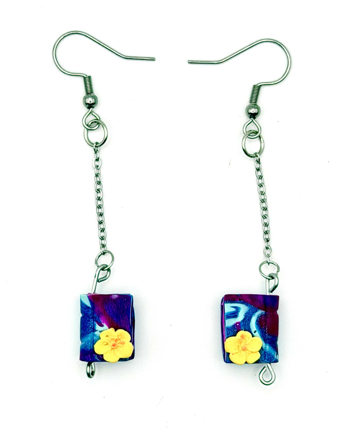 Handmade statement earrings featuring purple swirled polymer clay design, attached to silver chains and hooks.