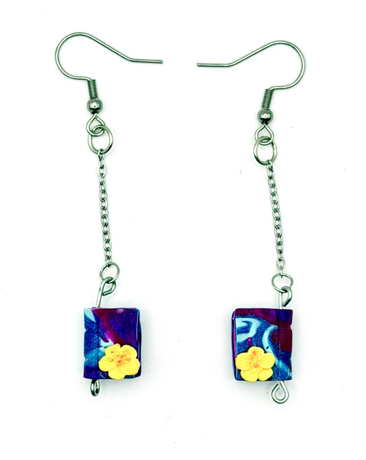 Handmade statement earrings featuring purple swirled polymer clay design, attached to silver chains and hooks.