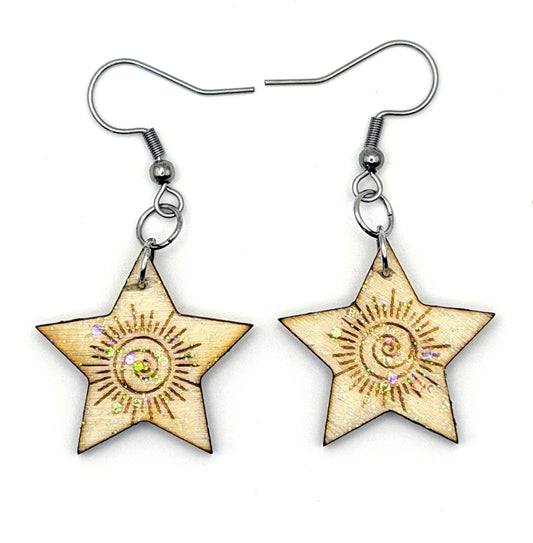 Laser cut and engraved wood earrings in a star shape, attached to silver hooks.