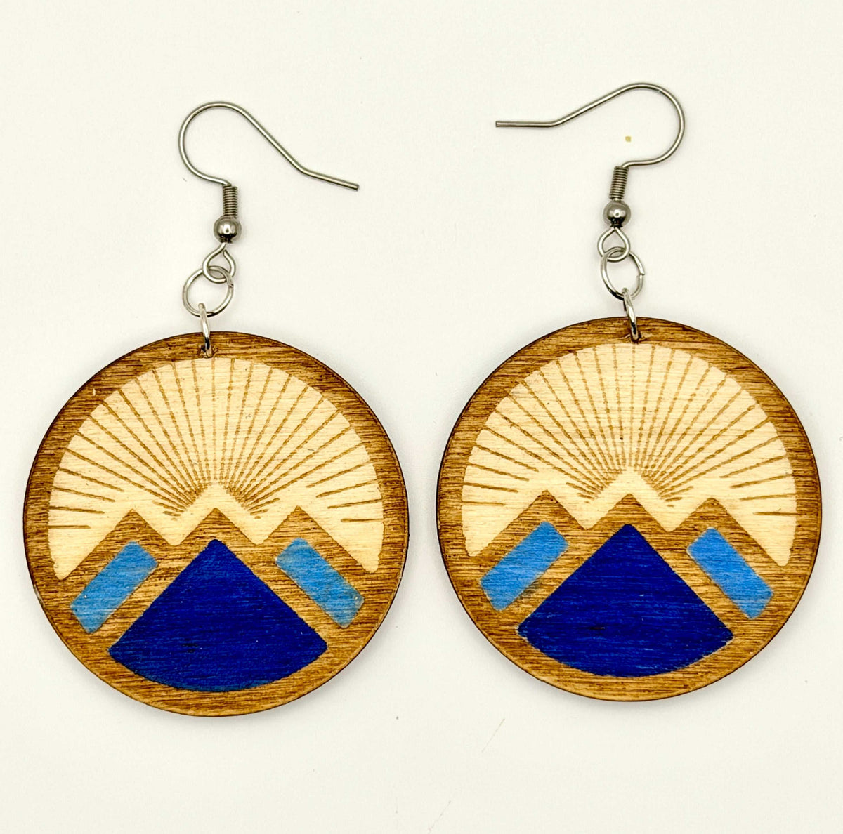 Engraved mountain statement earrings featuring blue painted accents, attached to silver hooks.
