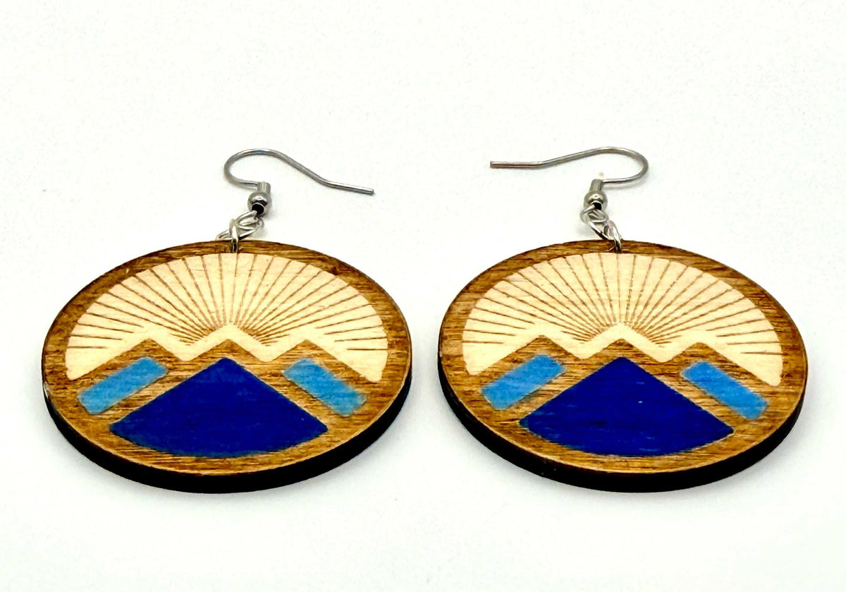Close-up of engraved mountain design earrings with silver hooks, showcasing unique engraved design with painted accents.