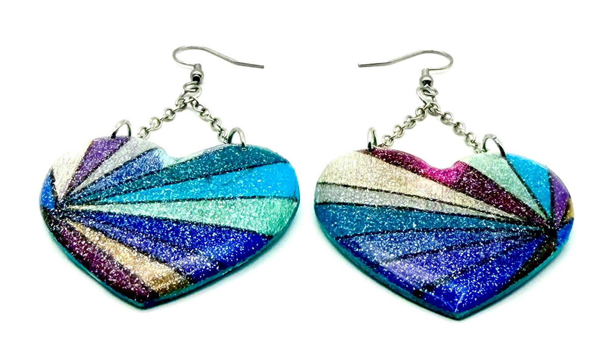 Close-up of hand painted multi-colored earrings with chain links and silver hooks, showcasing a unique hand painted design.