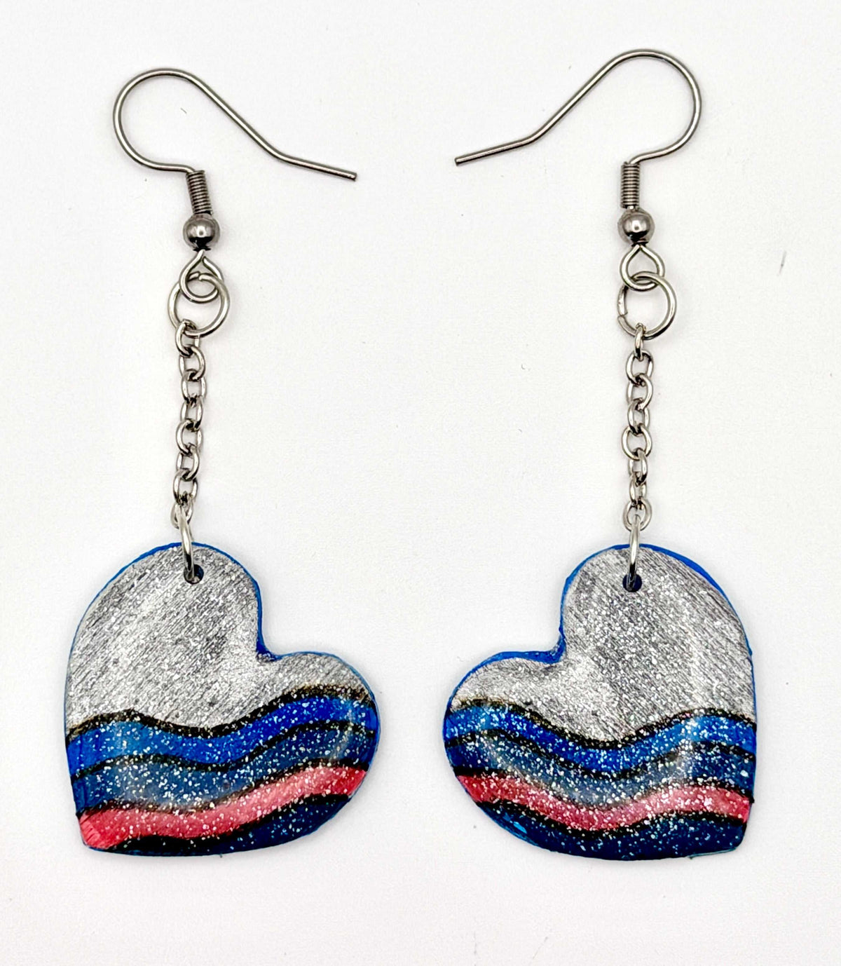 Handmade statement earrings featuring a grey hand painted design attached to silver chains and hooks.