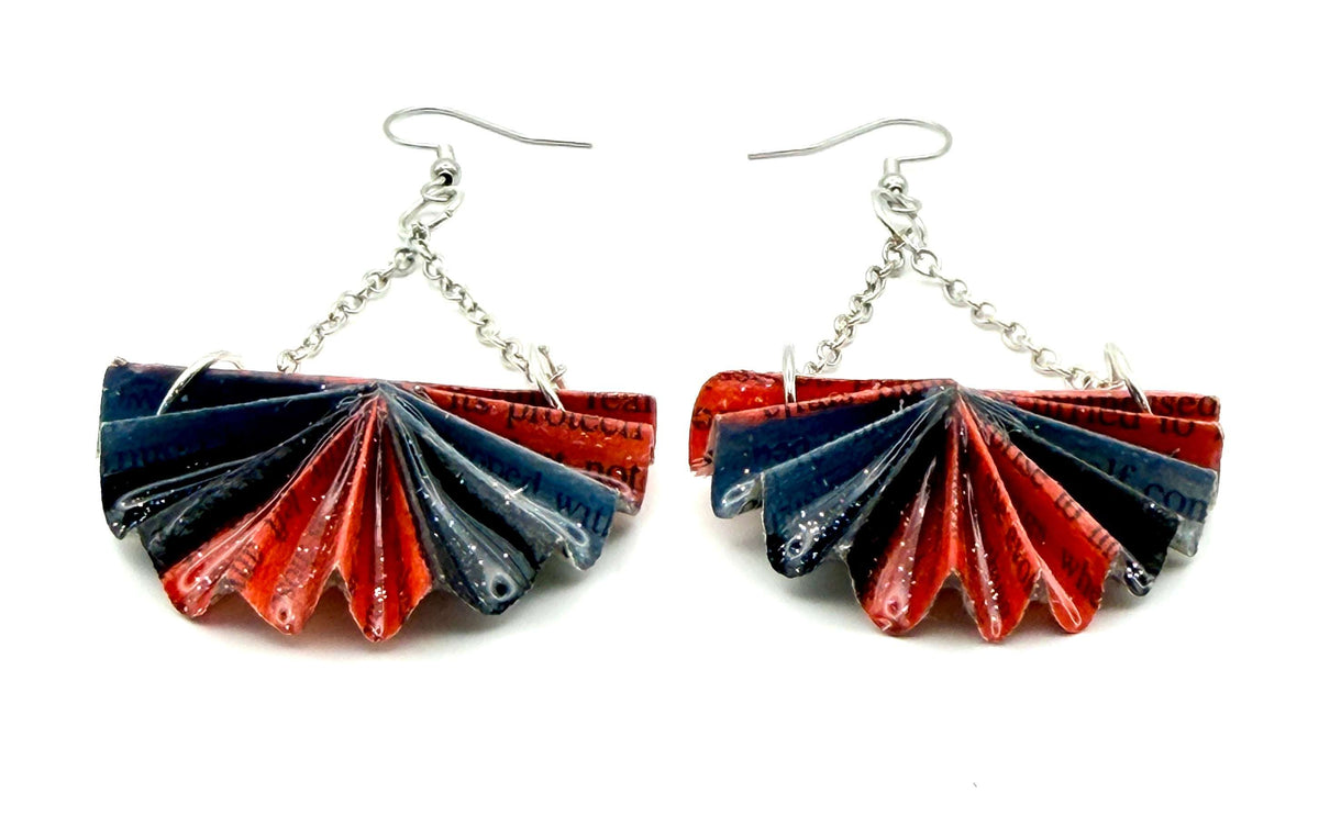 Close-up of red and black upcycled book page earrings with chain links and silver hooks, showcasing unique folded paper design.
