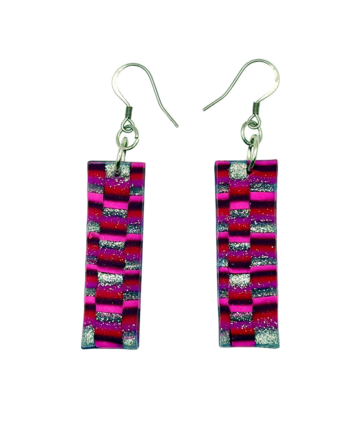 A pair of rectangular drop earrings with a vibrant pink, purple, and black striped pattern accented with silver glitter, hanging from silver fishhook wires on a plain white background.